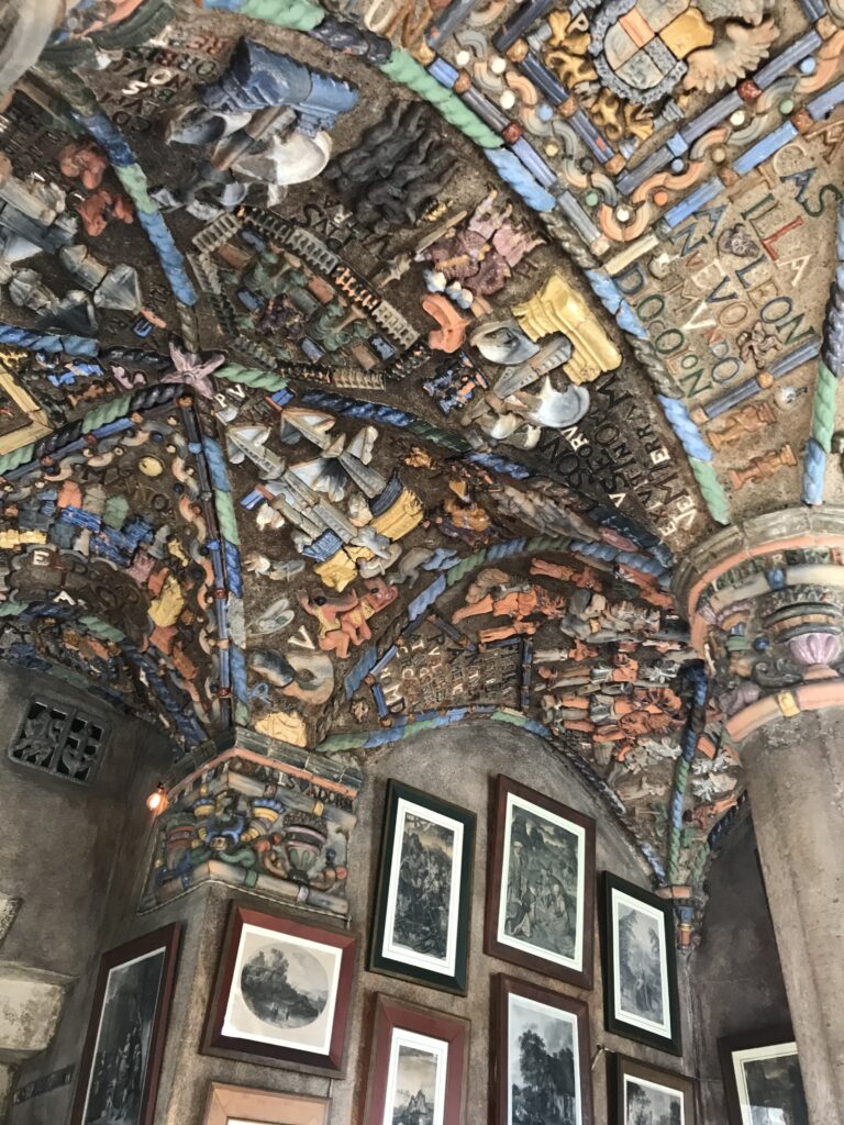 Intricate ceramic tile ceiling and wall display inside Fonthill Castle with colorful relief figures and framed artwork