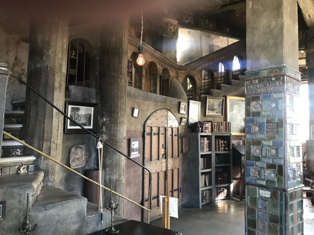 Interior of Fonthill Castle with rustic staircase, wooden door, tile column, and bookshelves