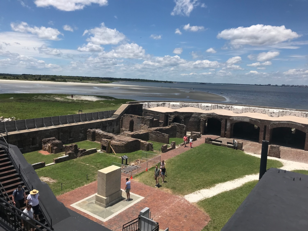 Visitors exploring the historic interior of Fort Sumter National Monument with views of Charleston Harbor