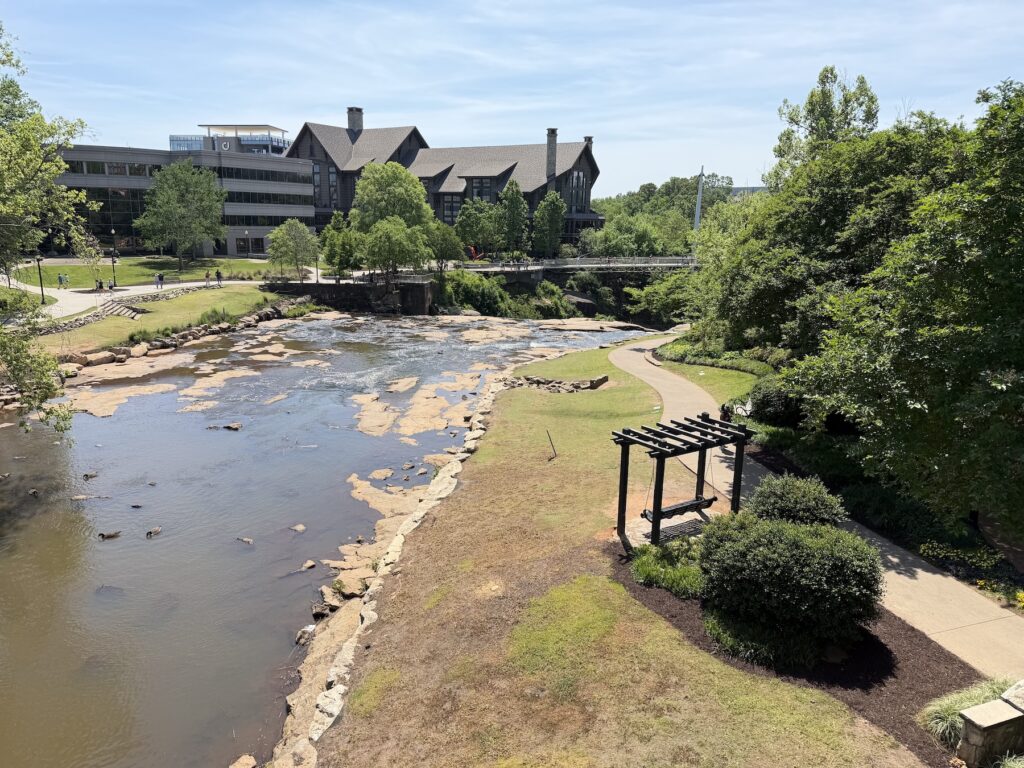 Reedy River and walking path in Falls Park on the Reedy with downtown Greenville buildings in the background