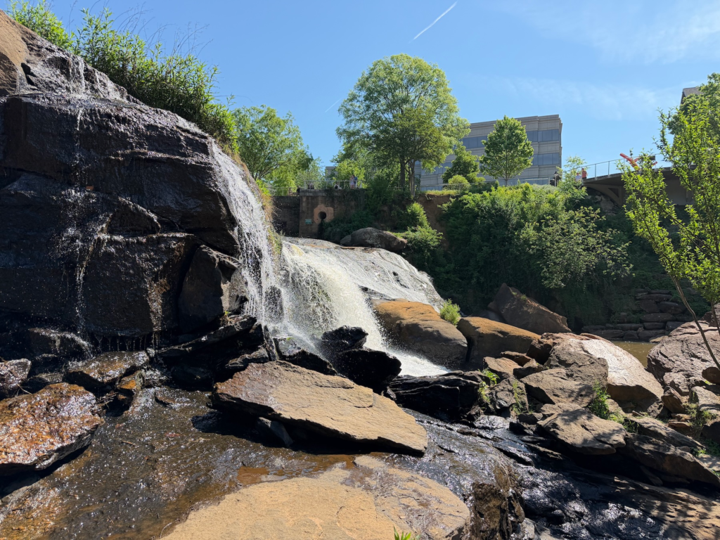 Water cascading over rocks at Reedy River Falls in Falls Park Greenville South Carolina on a sunny day
