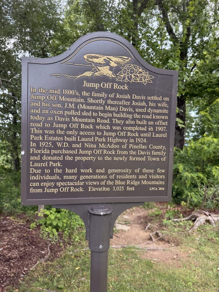 Historical marker at Jump Off Rock in Laurel Park, North Carolina, describing the overlook's history, early road construction, and development into a scenic park overlooking the Blue Ridge Mountains.