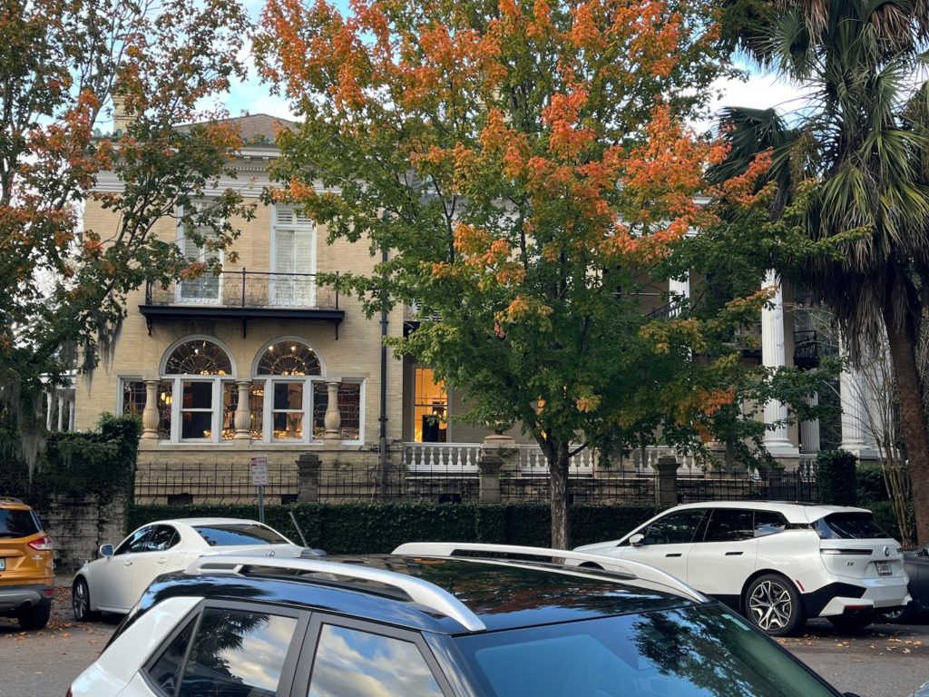 Historic Savannah mansion framed by colorful autumn trees