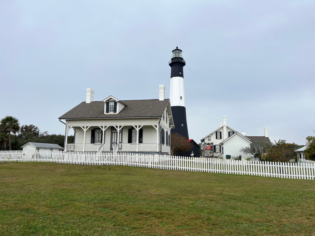 Tybee Island Lighthouse and keeper’s cottages behind a white picket fence
