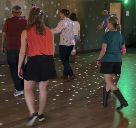 Guests participating in a line dancing lesson at Honeysuckle Holler in Hendersonville, North Carolina.