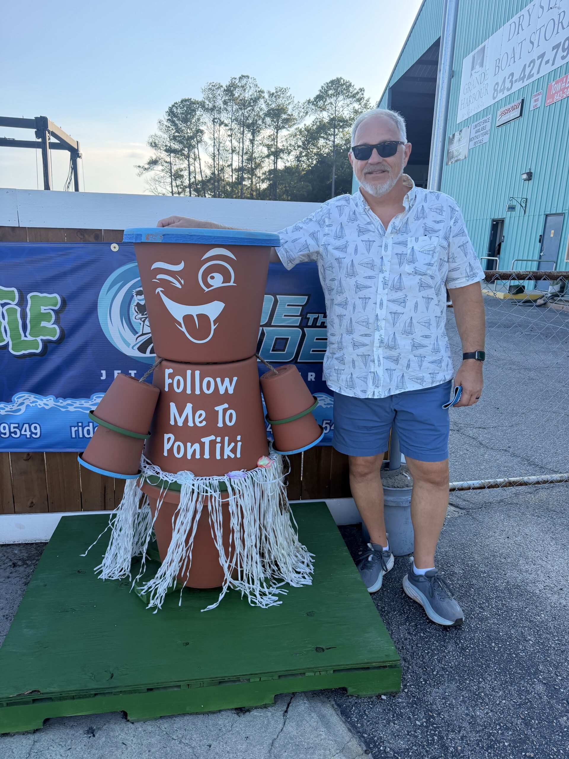 Nelson posing beside the Follow Me to PonTiki mascot before boarding the sunset cruise.